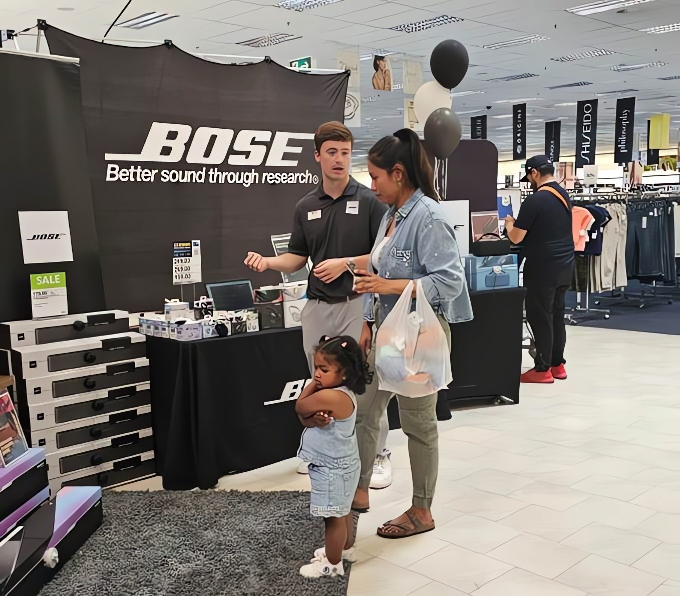 Bose in-store demonstration with an MSS associate assisting a customer and child