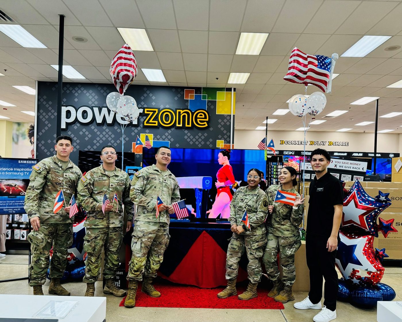 Samsung TV demonstration with service members and a Samsung associate in an exchange electronics department